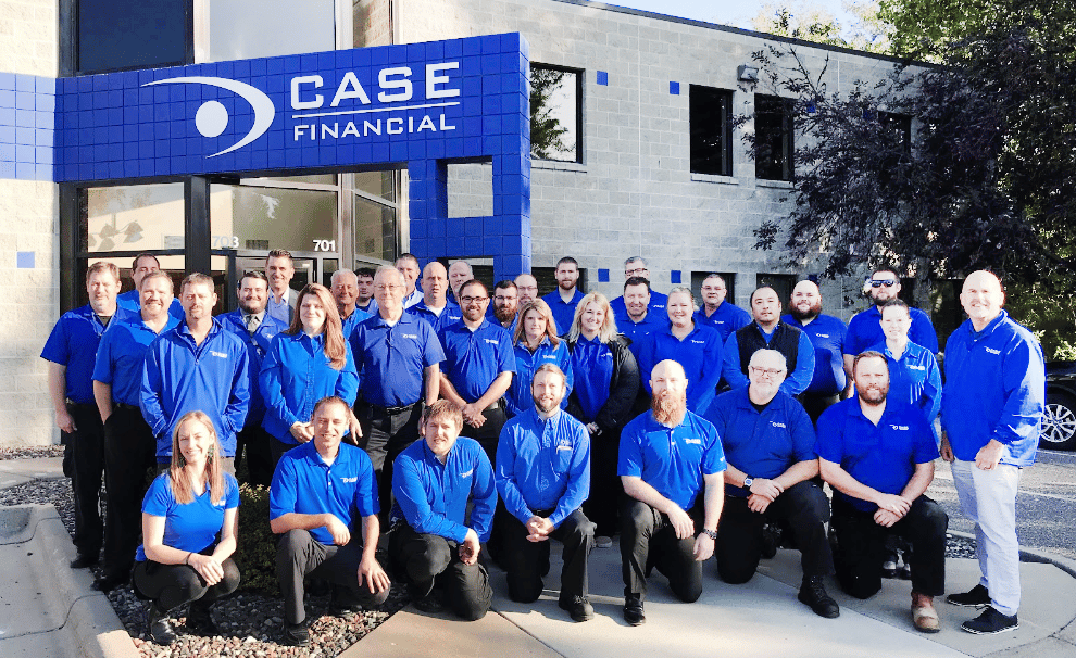 Employees standing in front of the case financial business smiling for a group photo
