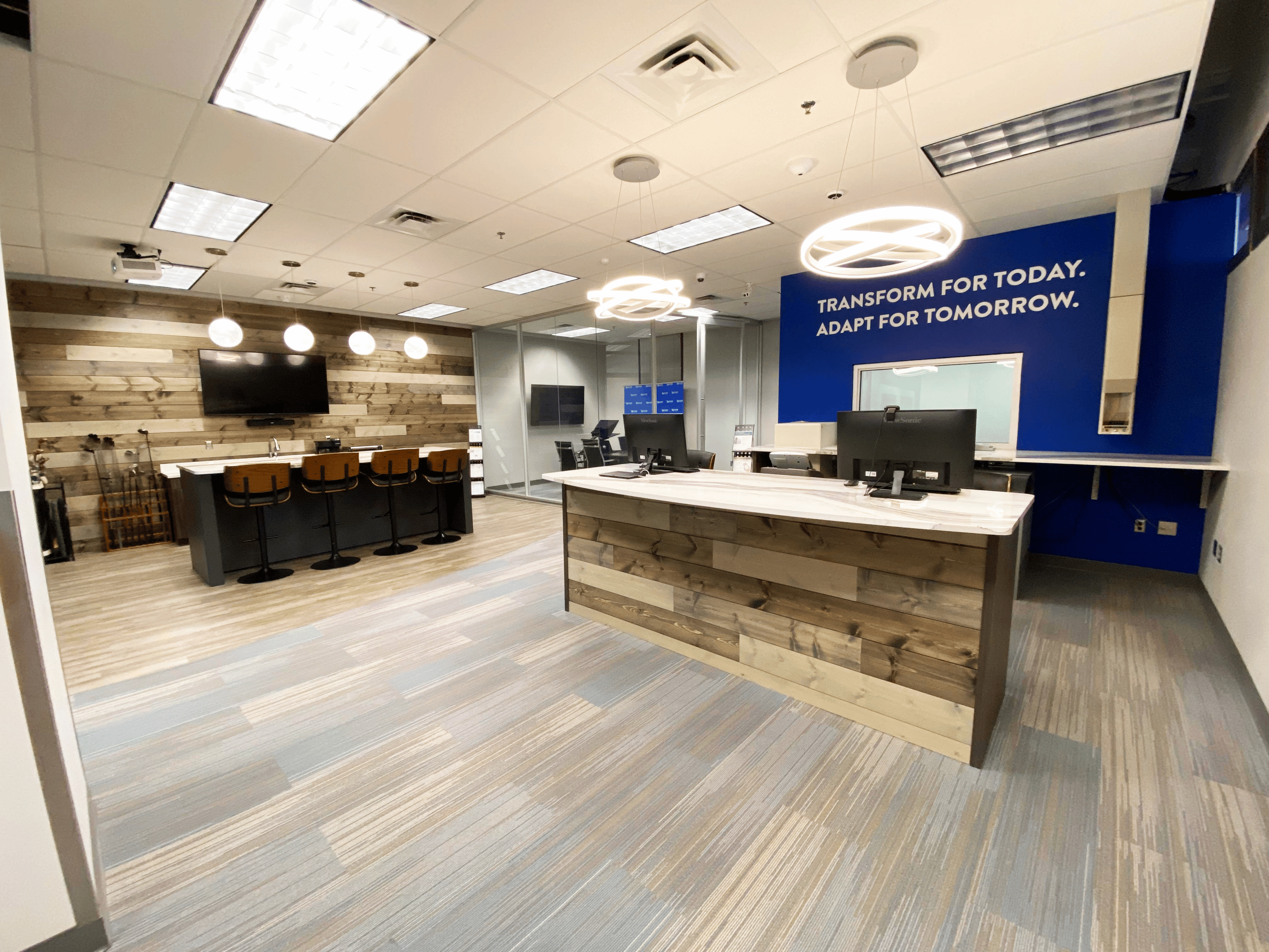 Interior shot of the Case Financial branch at an angle into the entrance. The blue wall behind reception reads, "Transform for today. Adapt for tomorrow."